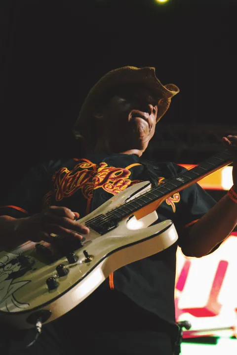 Guitarrista iluminado durante una presentación nocturna.